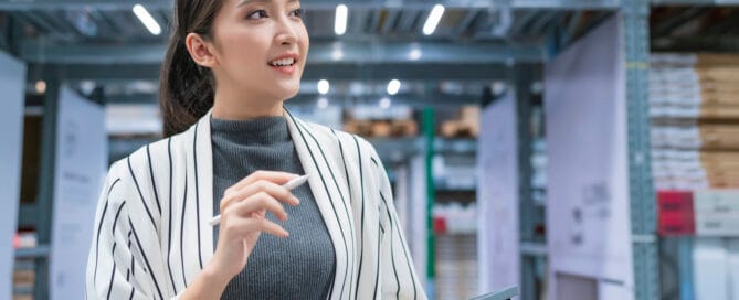 Portrait of asian woman business owner using digital tablet checking amount of stock product inventory on shelf at distribution warehouse factory.logistic business shipping and delivery service